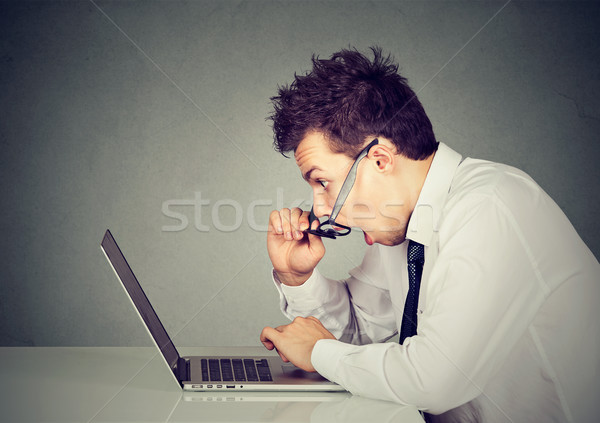 Shocked man looking at laptop computer amazed with open mouth  Stock photo © ichiosea