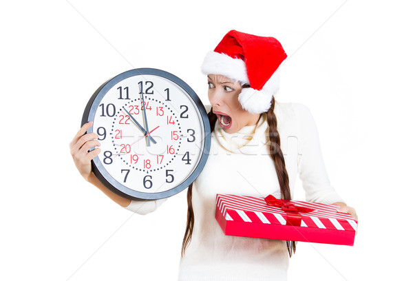 Stock photo: Young christmas woman holding clock and a gift box, running out of time, last minute shopping