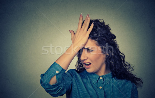 Stock photo: silly young woman, slapping hand on head having duh moment made mistake 