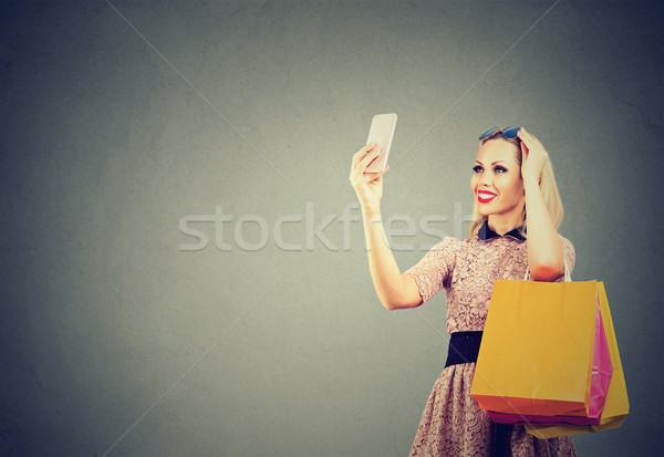 Beautiful woman shopping online taking selfies on mobile phone.  Stock photo © ichiosea