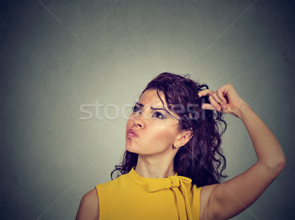Confused thinking woman bewildered scratching her head seeks solution  Stock photo © ichiosea