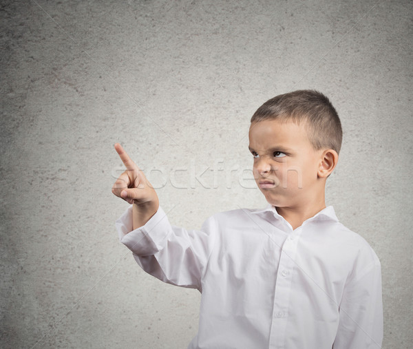 Unhappy boy pointing with finger at copy space Stock photo © ichiosea