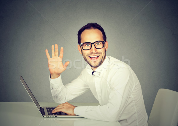 Man with laptop waving with hand saying hi to camera  Stock photo © ichiosea