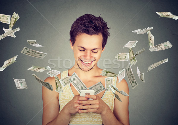 man using smartphone with dollar bills flying away from screen Stock photo © ichiosea