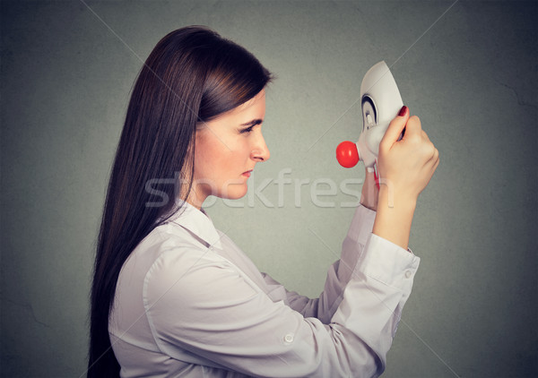 Serious upset woman looking at happy clown mask  Stock photo © ichiosea