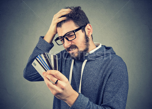 stressed man looking at too many credit cards Stock photo © ichiosea