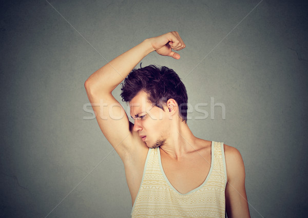man, smelling, sniffing his armpit, something stinks bad, foul odor  Stock photo © ichiosea