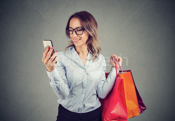 Beautiful woman shopping online checking prices on mobile phone Stock photo © ichiosea