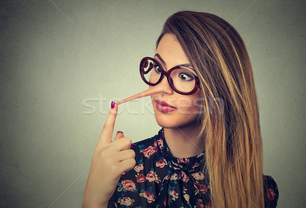 Woman with long nose isolated on grey wall background. Liar concept.  Stock photo © ichiosea
