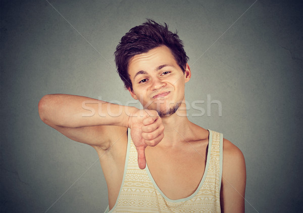 Angry unhappy man showing thumbs down sign in disapproval  Stock photo © ichiosea