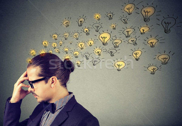 Man wearing glasses having many ideas thinking organizing thoughts  Stock photo © ichiosea