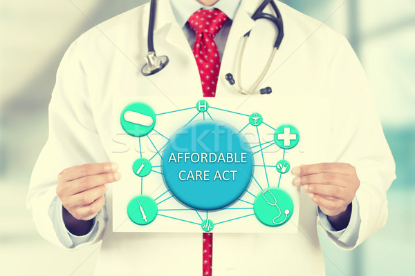 doctor hands holding white card sign with affordable care act text message Stock photo © ichiosea