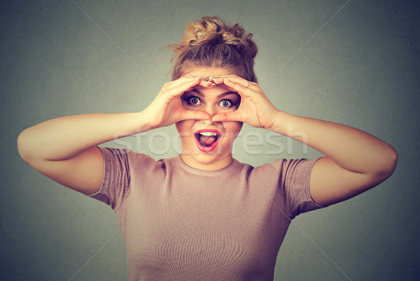 Surprise. Stunned curious woman peeking looking through fingers like binoculars  Stock photo © ichiosea
