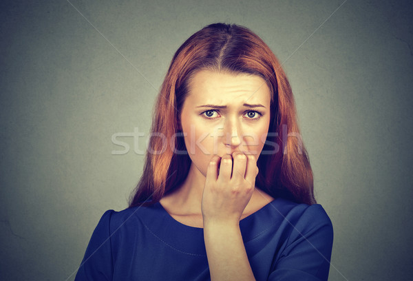 Stock photo: Nervous woman biting her fingernails craving something or anxious