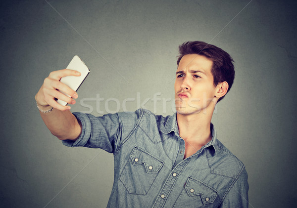 funny looking man taking pictures of himself with smartphone Stock photo © ichiosea
