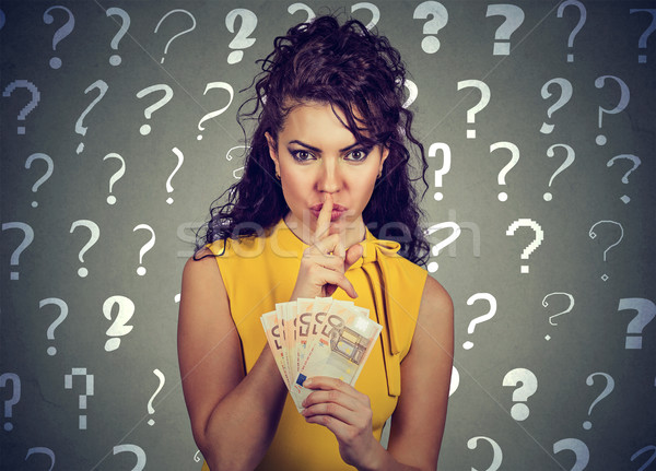 Young woman with finger on lips gesture and euro banknotes in hand Stock photo © ichiosea