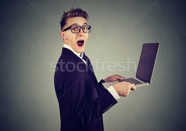 Surprised stunned man with laptop computer looking at camera Stock photo © ichiosea