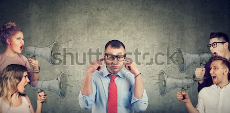Stock photo: Anxious man scared of being judged by different people. Concept of accusation of guilty guy. 
