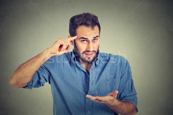 angry mad man gesturing with his finger against temple asking are you crazy? Stock photo © ichiosea