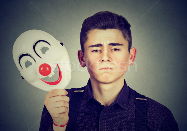 Sad man taking off happy clown mask. Split personality Stock photo © ichiosea