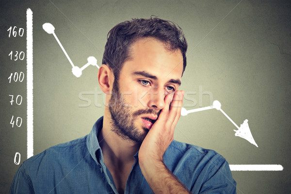 frustrated stressed young man desperate with financial market chart graphic going down Stock photo © ichiosea