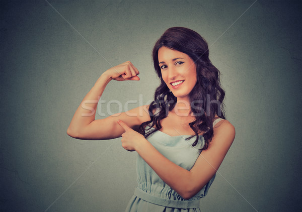 Fit young healthy model woman flexing muscles showing her strength  Stock photo © ichiosea