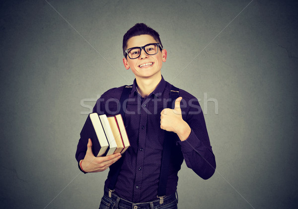 Young nerd man in glasses with book showing thumb up Stock photo © ichiosea