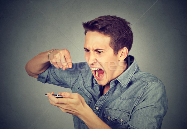 angry young man screaming on mobile phone i Stock photo © ichiosea