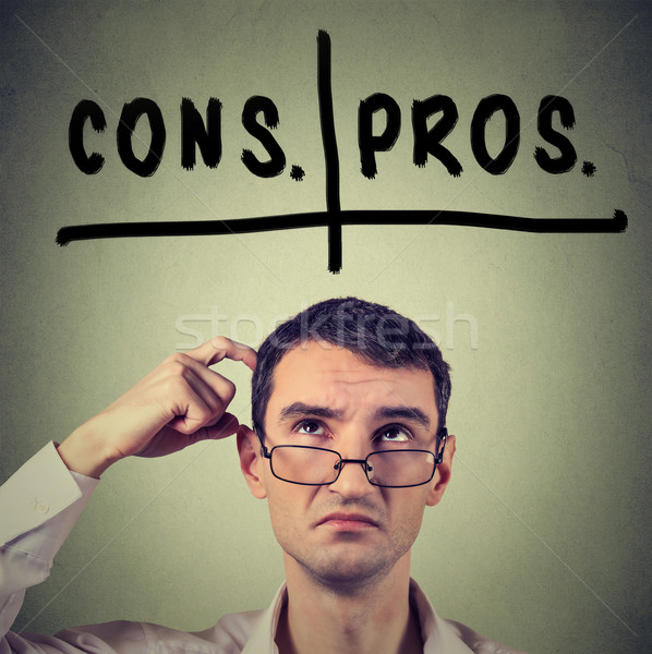 pros and cons, for and against argument concept. Man with glasses looking up deciding Stock photo © ichiosea