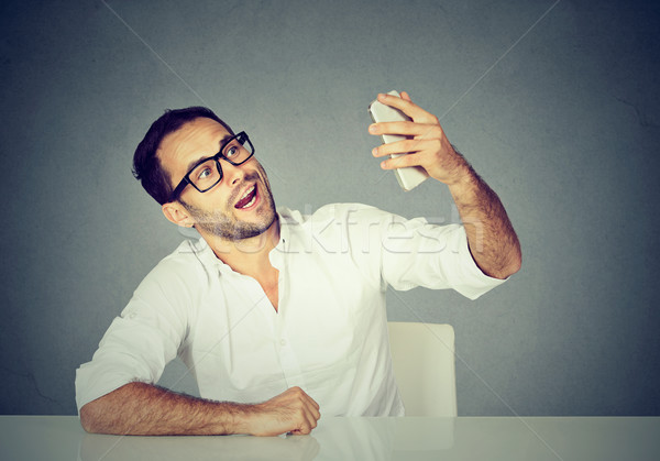 young funny looking man taking pictures of him self with smart phone Stock photo © ichiosea