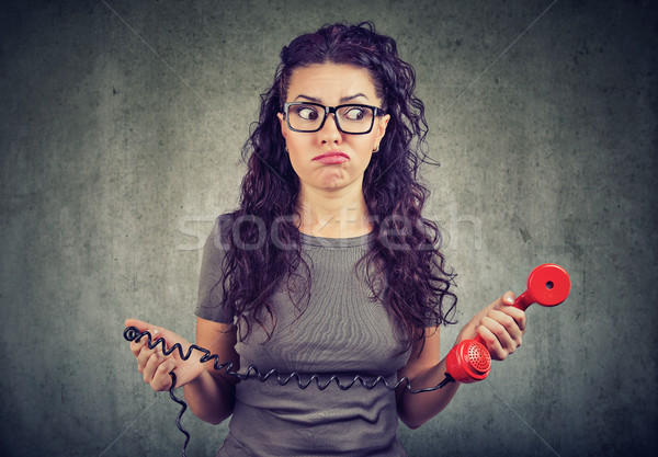 Stock photo: Confused woman with old phone