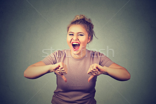 smiling young woman showing thumbs down gesture Stock photo © ichiosea