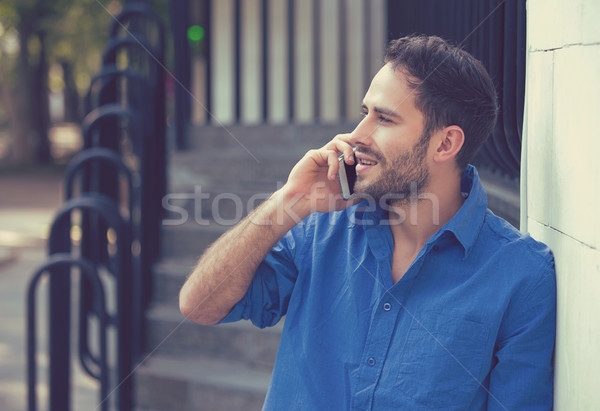 Stock photo: man holding mobile phone making a call outdoors 