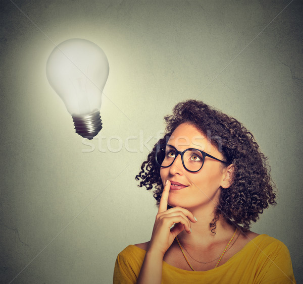 woman thinks looking up at bright light bulb Stock photo © ichiosea