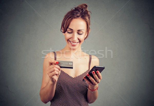 Smiling woman purchasing online with smartphone Stock photo © ichiosea