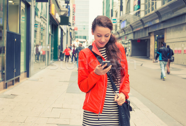 girl texting on the smart phone walking down the street Stock photo © ichiosea