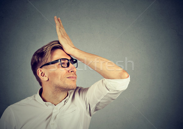 Stock photo: Silly man slapping hand on head having duh moment