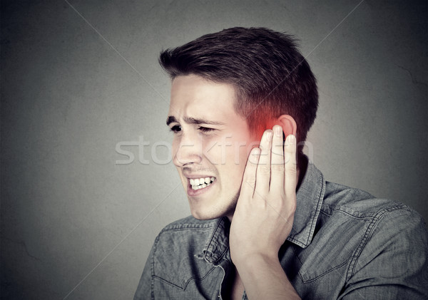 Tinnitus. Sick man having ear pain touching his painful head  Stock photo © ichiosea