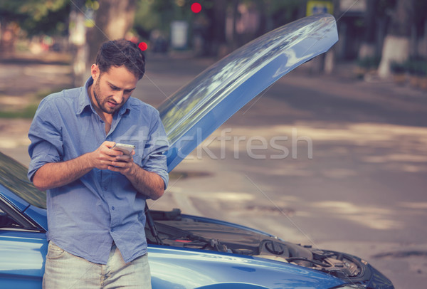 Upset man texting roadside assistance after breaking down Stock photo © ichiosea