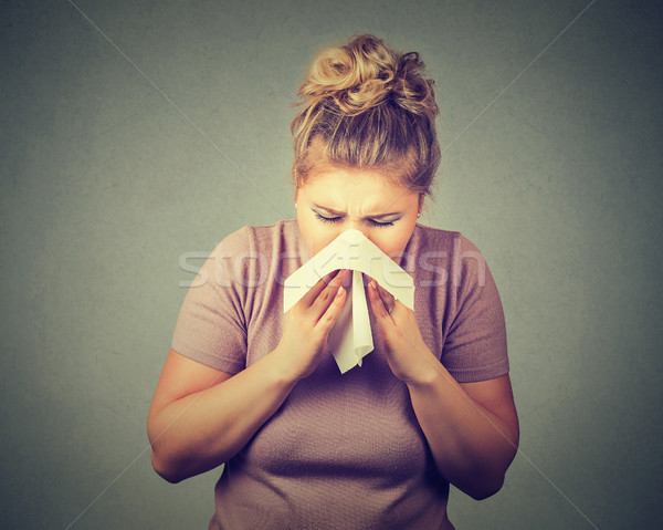 Woman sneezing in a tissue blowing her runny nose Stock photo © ichiosea