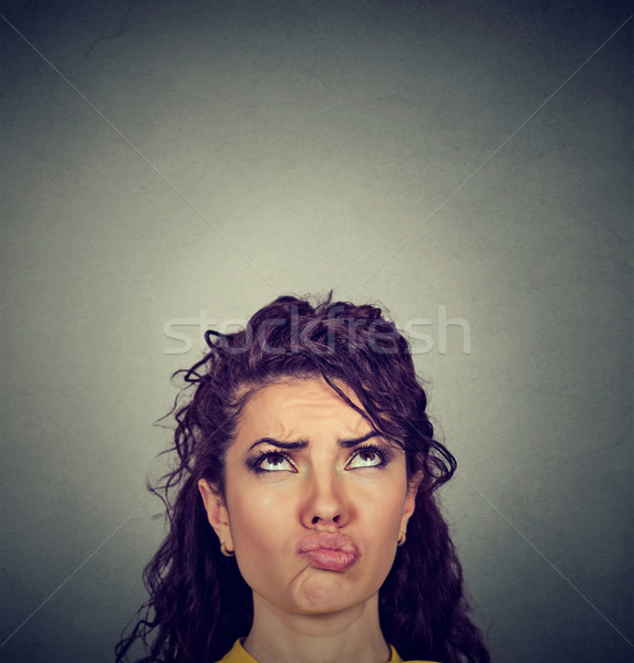 Doubtful perplexed young woman looking up  Stock photo © ichiosea