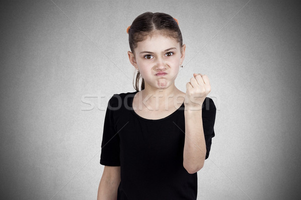 Angry little girl showing fist to someone Stock photo © ichiosea