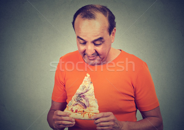Middle aged man eating craving a pizza. Unhealthy eating diet nutrition concept  Stock photo © ichiosea