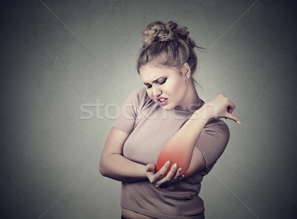 Joint inflammation with red spot on female's elbow. Arm pain injury concept. Woman with painful elbo Stock photo © ichiosea