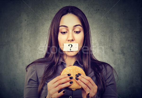 Woman on diet restriction with question mark on mouth looking at burger Stock photo © ichiosea