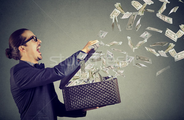Excited young business man opening an box letting dollar banknotes to fly away  Stock photo © ichiosea