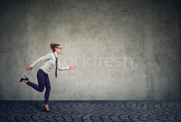 Businesswoman running against gray wall Stock photo © ichiosea