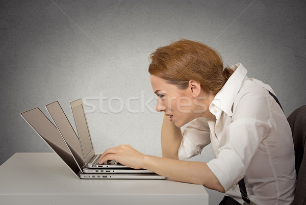 stressed young woman working on several computers Stock photo © ichiosea