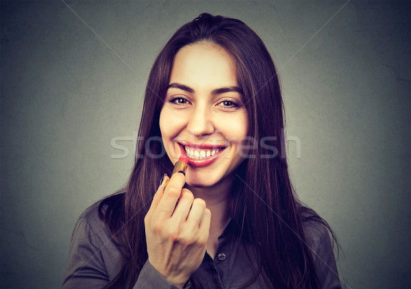 Beautiful woman applying lip balm.  Stock photo © ichiosea