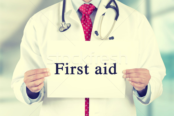 doctor hands holding white card sign with first aid text message Stock photo © ichiosea